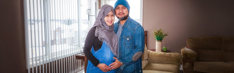 Immigrant husband with his pregnant wife inside their home.