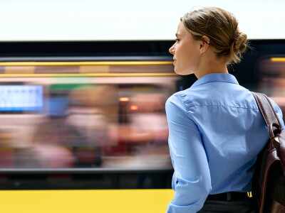 Professional woman at metro platform with moving train