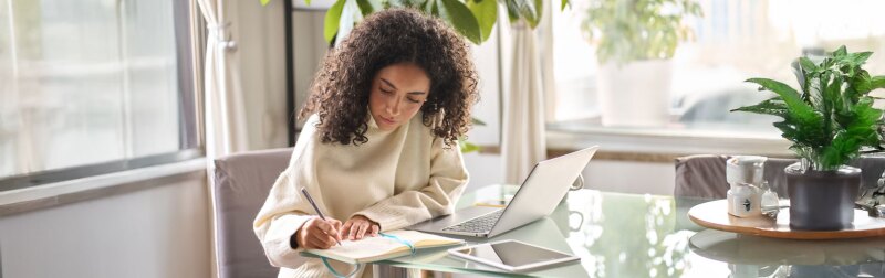 Young female student using laptop at home office using laptop for online learning.