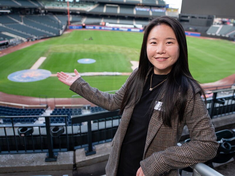 Smiling female student in the stands of Citi Field
