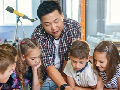 Teacher instructs his students, helps work through a project
