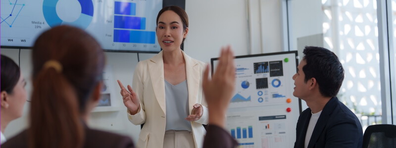 Business professional presenting data visualizations to colleagues during a team meeting.