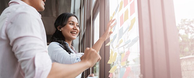 Two coworkers working on the key elements of a strategic business plan.