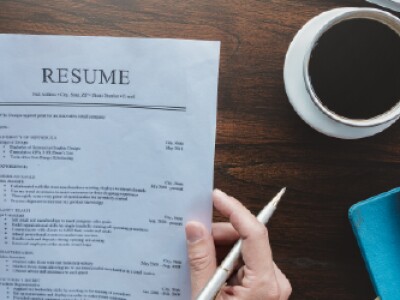 Paper resume on the desk next to coffee cup