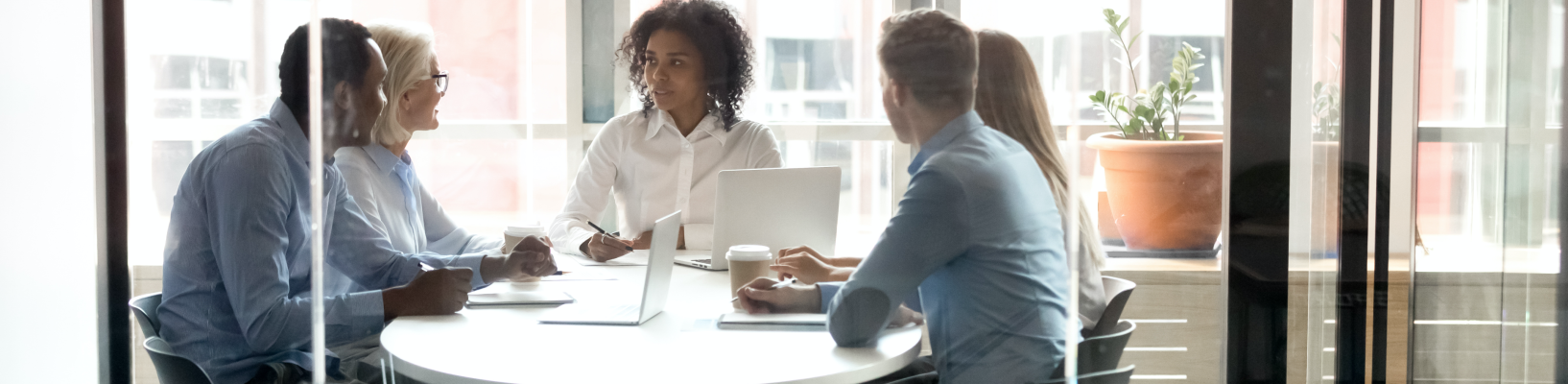 HR professionals sit around a table in a meeting