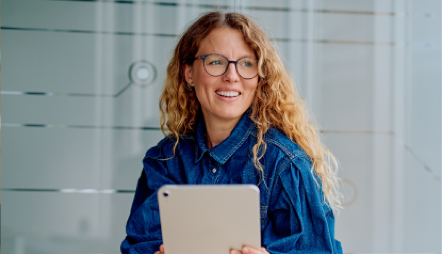 Closeup of a female CWRU student holding tablet against chest.