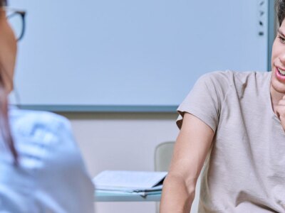 Young male student at meeting with college counselor in office.