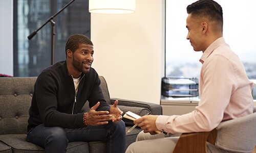 two men sitting across from each other having a discussion
