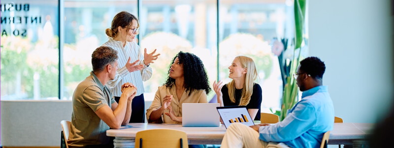 Business professional leads a collaborative meeting in a sunlit office