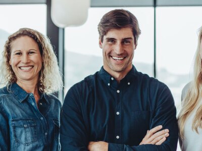 Successful business team standing together smiling, while in a conference room.