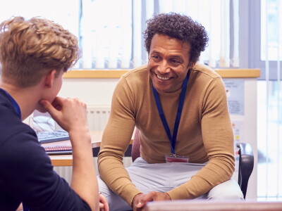 A counselor smiles encouragingly while listening to a young client