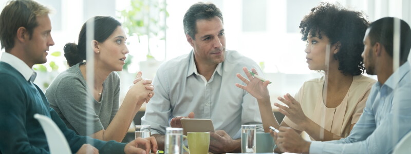 A marketing professional presents her ideas to four attentive colleagues
