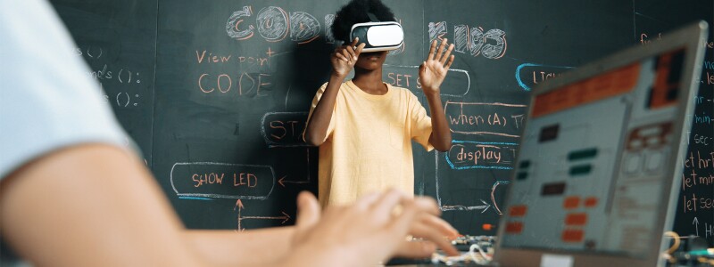 Boy wearing virtual reality glasses in an innovative class.