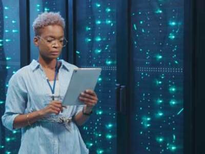 Tech professional in front of a bank of servers