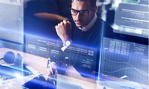 Man working on futuristic computer with multiple screens