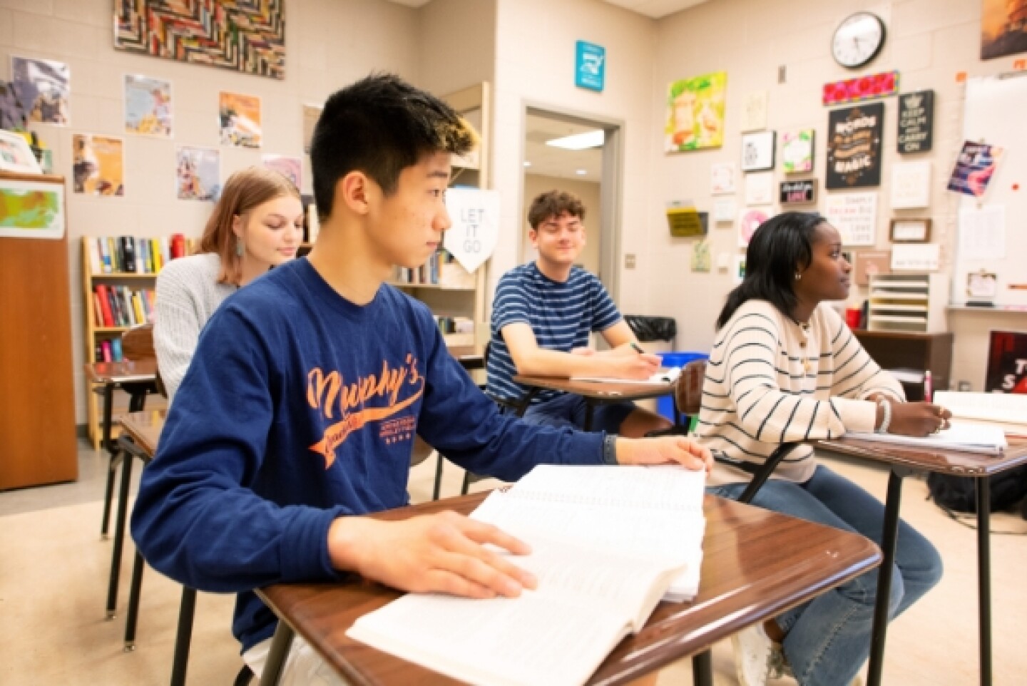 Diverse group of four students seated at desks
