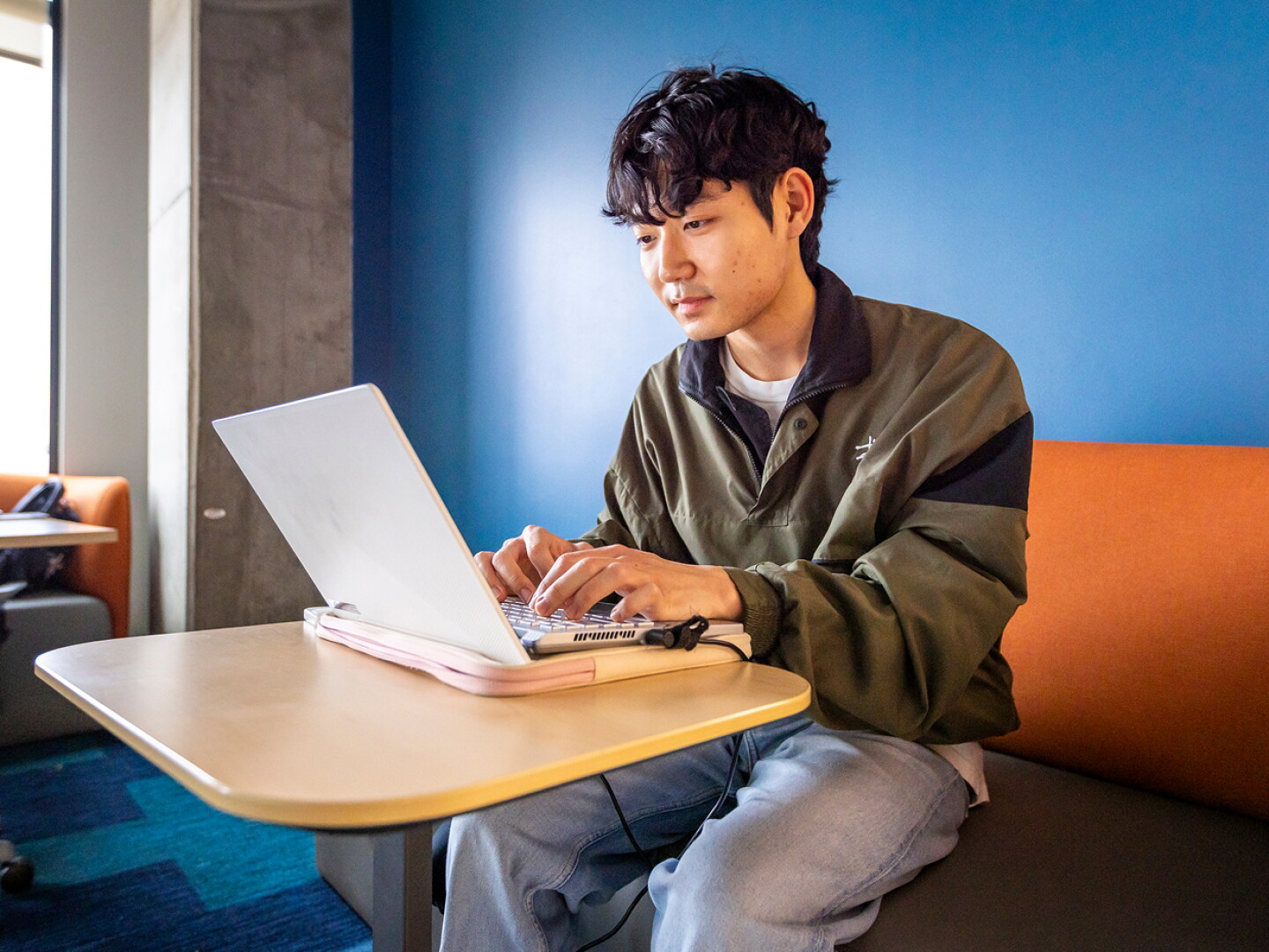 Man working on his laptop sitting in a modern office space