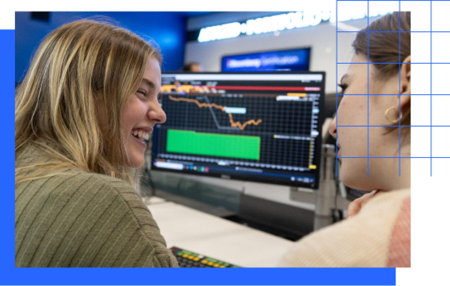 Two female KU Business student discussing class lecture while reviewing analytics.