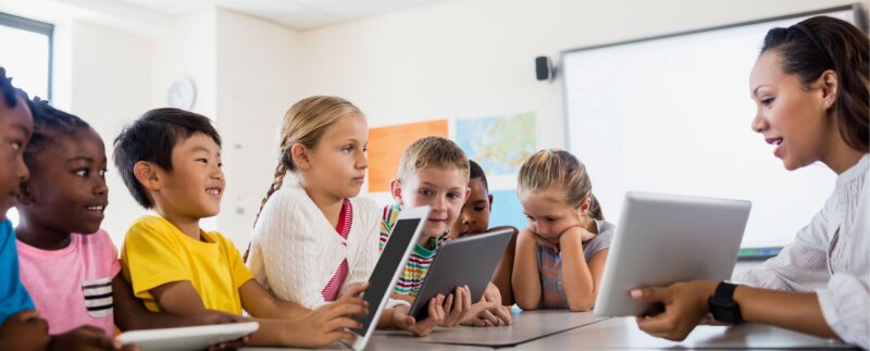 Teaching in a classroom of children teaching lessons using tablets that can gather evidence of learning.