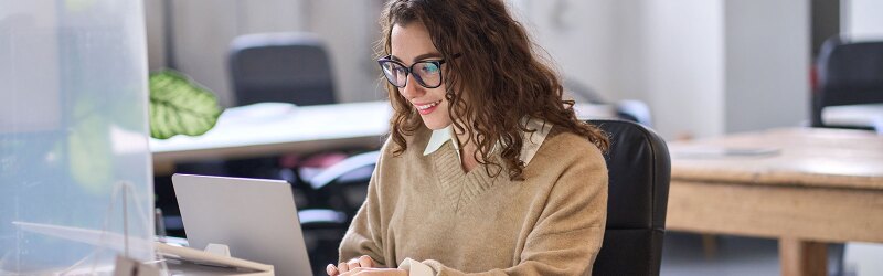 A woman looking at a laptop.