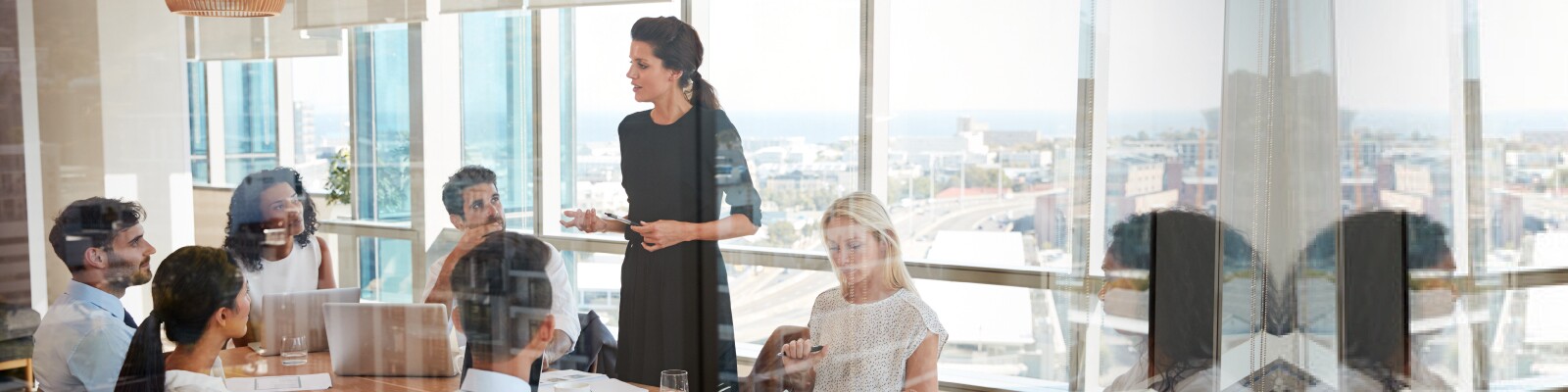Woman leads a meeting standing up at the table in conference room