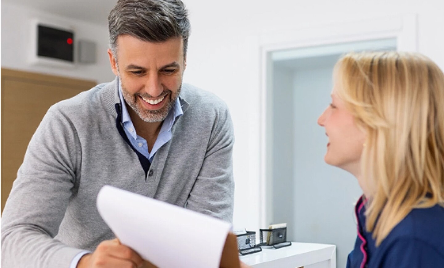 Healthcare compliance specialist consulting with female nurse at desk