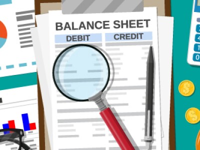 balance sheet on desk with calculator and magnifying glass