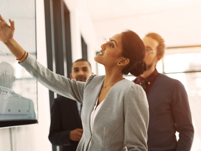 woman pointing to analytics on the screen with customers