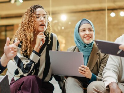 Wide Shot of a Multiethnic Group of People Discussing Ideas in a Meeting Room at Office.