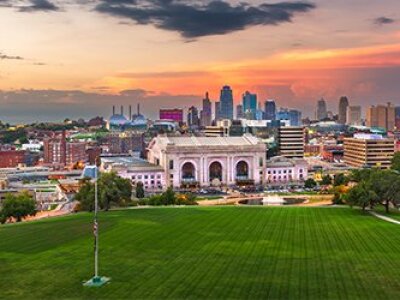 aerial-view-of-campus-city-in-background-at-sunset-green-lawn-in-front
