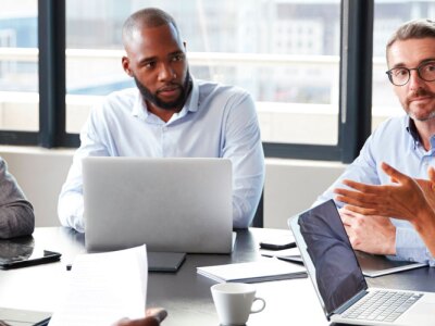 Millennial black businesswoman addressing colleagues at a corporate business meeting, close up.