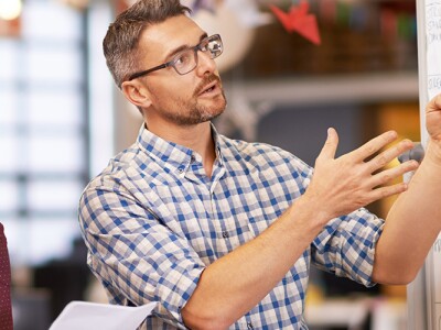 Group of coworkers brainstorming at a whiteboard