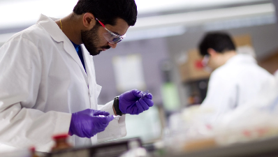 Man in lab with purple gloves