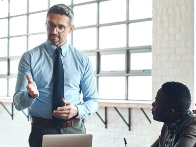 A business professional leading a discussion with a diverse group of colleagues in an MBA course environment.