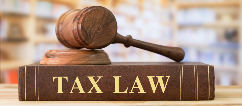 Image of gavel lying on top of a tax law book