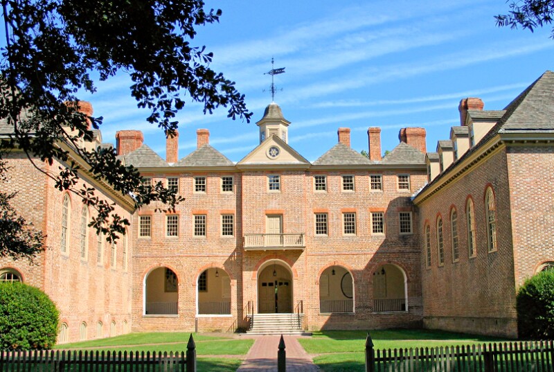 orange-brick-building-on-green-grass-with-blue-sky-and-tree-on-the-left