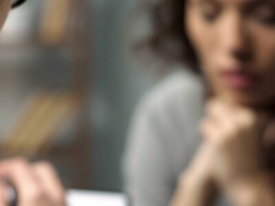Young depressed woman talking to female counselor about her mental health during session.