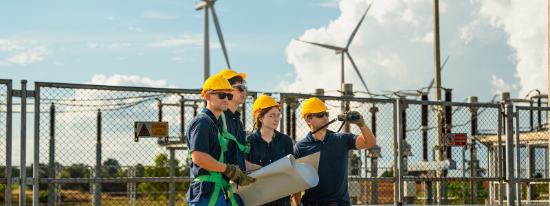 Wind energy engineering team inspecting high-voltage substation infrastructure at renewable power plant