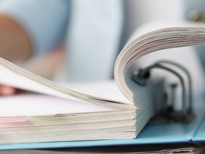 Closeup of woman examining finance regulation documentation in folder.