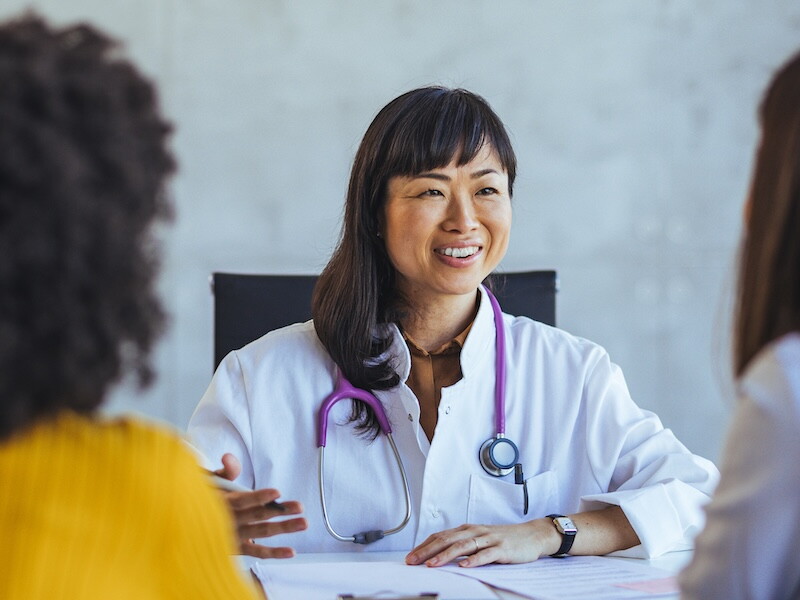 A physician discusses a clinical trial with two possible participants