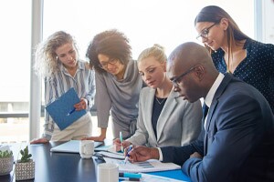 Focused group of office colleagues reading paperwork in a boardroom.