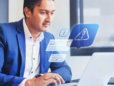 man in blue suit looking at computer with hazard sign and tabs in the air