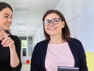 Two teachers walking down the hallway and talking