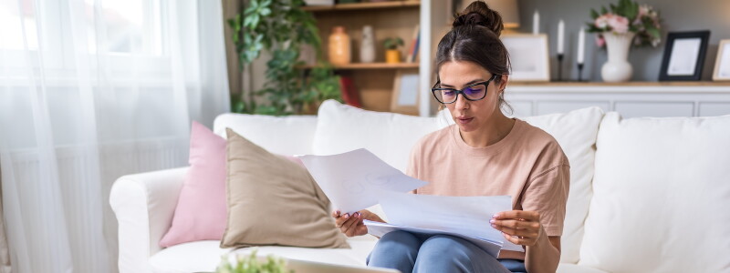 Seated at home, a nursing student reviews financial paperwork