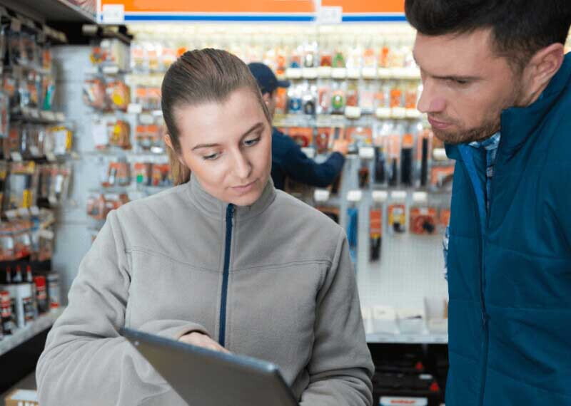 A supervisor reviews inventory with an employee in a hardware store