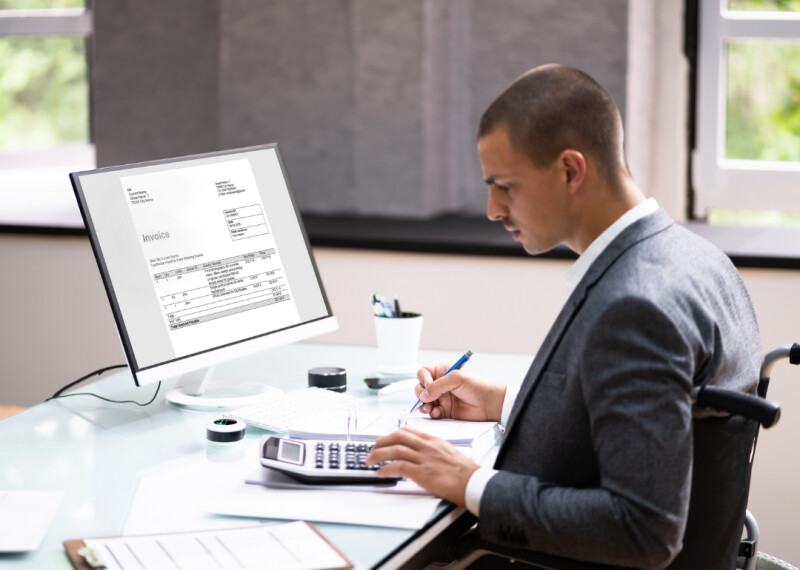Man sitting at desk in office uses a calculator