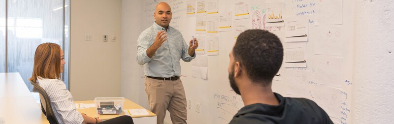 A group of people working around a whiteboard.