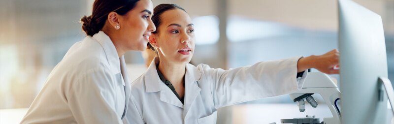 Female health professionals on computer for laboratory advice, medical research and night planning.