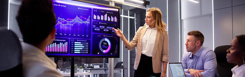 A group of people looking at data on a large computer screen.