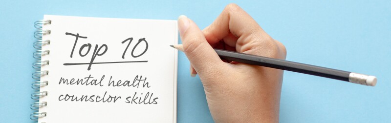 Hand of a woman writing in notebook; Top 10 mental health counselor skills